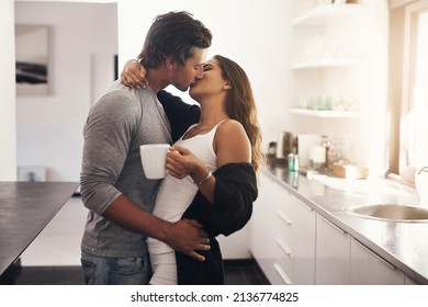 I Would Like A Kiss With My Morning Coffee. Shot Of A Young Couple Making Out In The Kitchen.