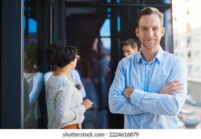 I Wouldnt Be Anything Without My Team. Portrait Of A Businessman Standing On A Balcony With His Arms Crossed And His Coworkers In The Background.