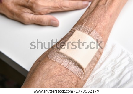 Wound bandage, Dressing arm wound with sterile plaster pad, Accidental wound care treatment in elder old man.
