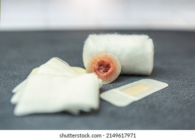 Wound Care Concept: Close-up Of A Fake Wound Surrounded By Different Bandage Material On Black Background