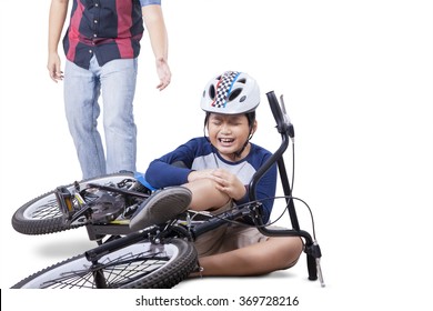 Wounded Child Falling From His Bike And Crying While Holding His Knee With Dad Coming To Help, Isolated On White