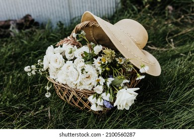 Woven Basket Full Of Wildflowers And Large Sun Hat