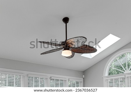 Woven Elegant Ceiling Fan Light Fixture in Sunroom Interior with White Ceiling and Arch Window