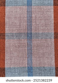 A woven fabric pattern with alternating black and white designs, featuring a repeated diamond-like motif. The design is framed by blue vertical stripes in the center, which adds contrast to the graysc