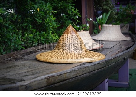 Woven hat made of bamboo on a wooden table for selective focus at floating market in the temple of Thailand.