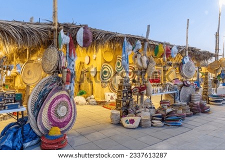 Woven mats and baskets from dried palm leaves with enlarged images. Traditional art and handicrafts in Doha, Qatar