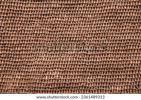 Woven natural straw texture. Background texture or pattern from a basket, woven with natural straw-colored reeds. Natural Plant Fibre Jute Burlap. Eco-Friendly, Reusable In Natural Brown Color