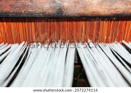 Woven threads background . Tapestry Loom with wooden base . Ancient Loom with white threads