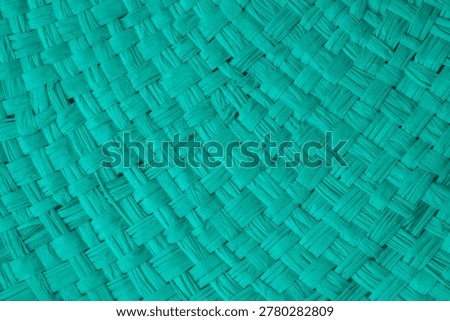 Woven turquoise material forms a repeating pattern of interlaced strands.