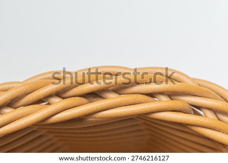 Woven wicker creating a textured pattern on the edge of a basket with white background