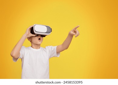 Wow, its amazing. Boy experiencing virtual reality, gesturing on orange studio background, copy space - Powered by Shutterstock