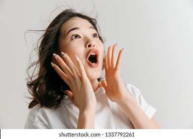 Wow. Beautiful female half-length front portrait isolated on gray studio backgroud. Young emotional surprised asian woman standing with open mouth. Human emotions, facial expression concept. - Shutterstock ID 1337792261