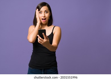 Wow, I Can't Believe This. Surprised Woman Looking At The Camera While Reading A Text Message On Her Smartphone