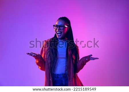 Wow emotions. Portrait of female fashion model in cotton shirt isolated on purple background in neon light. Concept of beauty, art, fashion, youth, sales and ads. Pretty woman posing