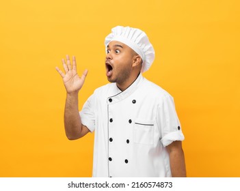 Cara emocionada Joven y guapo chef asiático uniformado que está de pie mirando el espacio en blanco para el menú en aislado. Cocinando al hombre indio El chef de la ocupación People in the cocina restaurant and hotel.