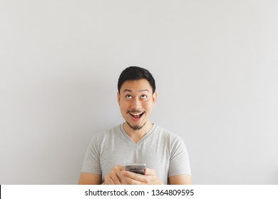 Wow Face Of Asian Man In Grey T-shirt Get Surprised On The Smartphone.