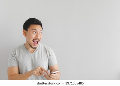 Wow Face Of Asian Man In Grey T-shirt Get Surprised On The Smartphone.