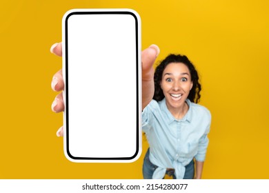 Wow, Great Offer. Excited Woman Showing Big White Empty Smartphone Screen Close Up To Camera Recommend Cellular App On Orange Studio Wall, Selective Focus On Hand. Check This Out, High Angle Top View