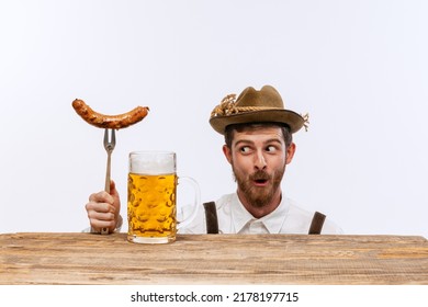 Wow. Happy Man Wearing Traditional Fest Bavarian Or German Outfit With Big Beer Glass And Fried Sausage Celebrating Oktoberfest. Alcohol, Traditions, Holidays, Taste Concept. Copy Space For Ad