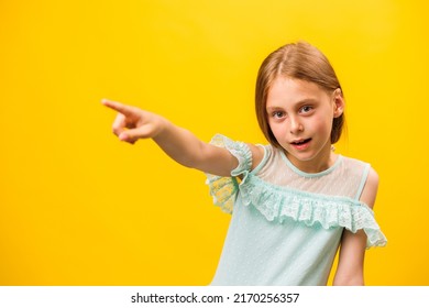 Wow look, advertise here Portrait of amazed cute kid girl pointing to empty place on yellow background, kid warning and childhood concept, copy space - Shutterstock ID 2170256357