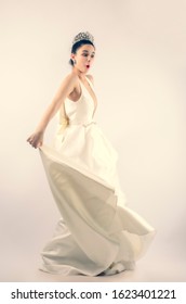 Wow, No Way. Portrait Of Amazed Bride Young Woman In White Dress And Against Light Light Background