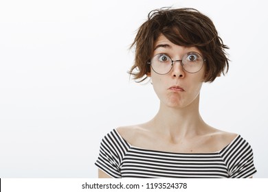 Wow, Not Bad I Am Impressed. Portrait Of Cute Pleased And Funny Girl In Round Glasses Pulling Chin And Making Faces While Standing Over Gray Background, Facing Something Unexpected