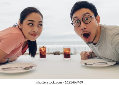 Wow And Shocked Face Of Asian Lover Couple Having A Date At The Restaurant On The Beach.