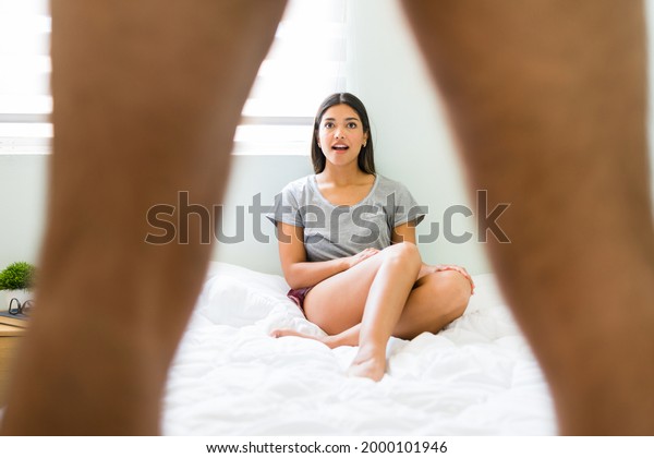 Wow! Shocked young woman feeling\
surprised while looking at her boyfriend\'s penis and erection.\
Amazed girlfriend looking between a young man\'s\
legs