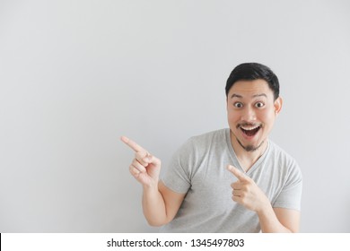 Wow And Surprised Face Of Asian Man In Grey T-shirt With Hand Point On Empty Space.