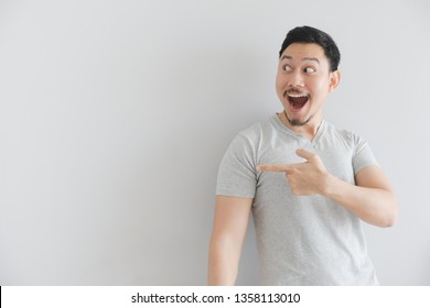 Wow And Surprised Face Of Asian Man In Grey T-shirt With Hand Point On Empty Space.