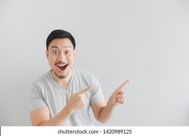 Wow And Surprised Face Of Asian Man In Grey T-shirt With Hand Point On Empty Space.