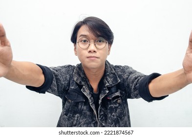 Wow And Surprised Face Of Young Asian Man Feeling Happy, Excited And Positive. Asian Man Open Arms For A Hug And Giving Surprise Gesture. Billboard Advertisment Model Concept.