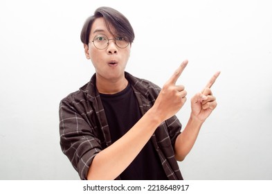 Wow Surprised Young Asian Man In Casual Shirt Pointing Finger To Copy Space Isolated Over White. Billboard Advertisment Model Concept. Student And Millenial Worker Concept.