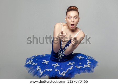 Wow, is that you? Amazed ballerina woman in blue costume with makeup standing against gray background and looking at camera with big eyes. emotion and expression concept. indoor studio shot.