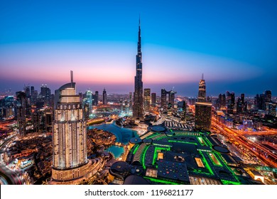 WOW view of Dubai skyline at night. City lights popping. Blue sky. Iconic landmarks. Luxury travel holiday concept.