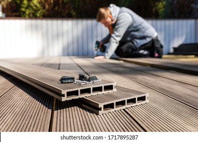 Bau einer wpc-Terrasse - Arbeiter, der Holzplatten aus Verbundwerkstoffen installiert