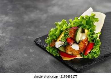 Wrap Sandwich, Roll With Chicken Meat, Vegetables, Lettuce. Tortilla, Burrito Wraps With Chicken, Tomatoes, Onion On A Dark Background. Copy Space.