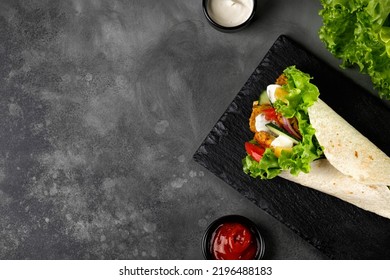 Wrap Sandwich, Roll With Chicken Meat, Vegetables, Lettuce. Tortilla, Burrito Wraps With Chicken, Tomatoes, Onion On A Dark Background. Top View, Copy Space.