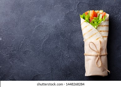 Wrap Sandwich, Roll With Fish Salmon And Vegetables. Dark Background. Copy Space. Top View.