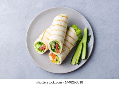 Wrap Sandwich, Roll With Fish Salmon And Vegetables. Grey Background. Top View.