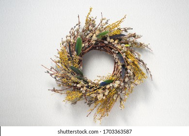 A wreath of dried twigs and flowers on a light gray background. Natural decoration. Holiday concept. Easter wreath. Willow round frame. Postcard design concept.