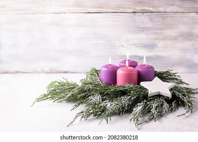 Wreath with four burning purple advent candles on a white wooden background with festive bokeh lights, Christmas catholic tradition. - Powered by Shutterstock