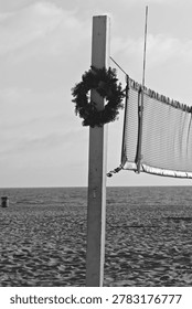 A wreath hangs from a volleyball net post on the sand in Hermosa Beach, California.