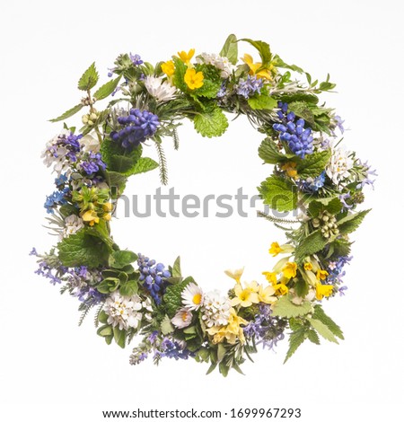 Wreath of wild spring flowers on white background