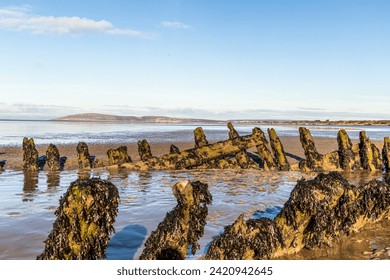 The wreck of the Norwegian ship SS Nornen which ran aground on the beach at Berrow Burnham-on-Sea and Brean Beach bay with a view of Brean Down.