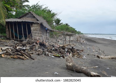 Wrecked Bamboo Hut, Burnt Driftwoods And Ocean Debris Along Sea Shore