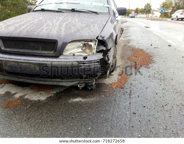 Wrecked\
car on road - broken headlight and front\
bumper