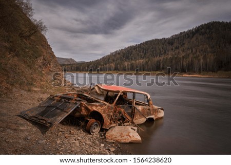 A wrecked car at the river bank near Krasnoyarsk, Russia.                               