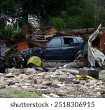 A wrecked car is seen in the aftermath of a tornado, highlighting the severe damage and destruction caused by the powerful storm.