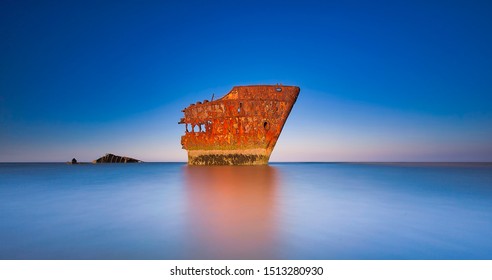 The wrecked ship, Baltray shipwrack, Shipwrecked off the coast of Ireland, An shipwreck or abandoned shipwreck,,boat Wreck Sunset light at the beach, Wrecked boat abandoned stand on beach or Shipwreck